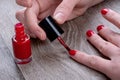 Female hands painting red nail varnish Royalty Free Stock Photo