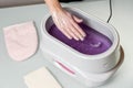 Female hands in a paraffin wax bowl