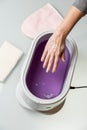 Female hands in a paraffin wax bowl