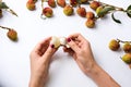 Female hands peeling lychee fruit