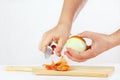 Female hands peeling raw onion with a knife on a cutting board Royalty Free Stock Photo
