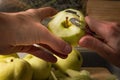 Female hands peeling skin off of green apple using a paring knife Royalty Free Stock Photo