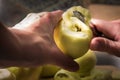 Female hands peeling skin off of green apple using a paring knife Royalty Free Stock Photo