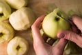 Female hands peeling skin off of green apple using a paring knife Royalty Free Stock Photo