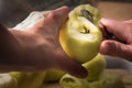 Female hands peeling skin off of green apple using a paring knife Royalty Free Stock Photo