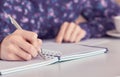 Female hands with pen writing on notebook at white office table. Royalty Free Stock Photo