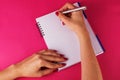 Female hands personal diary on pink background