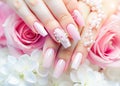 Female hands with pink manicure and white rose flowers on white background Royalty Free Stock Photo