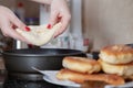 Female hands placing an unfried pie on a frying pan Royalty Free Stock Photo