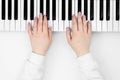 Female hands play the electronic piano on a white background, top view.