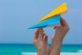 Female hands playing with paper planes on the beach Royalty Free Stock Photo