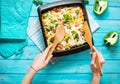 Female hands poured baked pasta with broccoli and cheesy tomato sauce Royalty Free Stock Photo