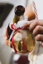 Female hands pouring champagne into a light bilb shaped party glass Royalty Free Stock Photo