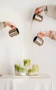 Female hands pouring matcha tea to milk for matcha latte