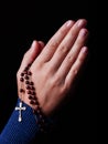 Female hands praying holding a beads rosary with Jesus Christ in the cross or Crucifix Royalty Free Stock Photo
