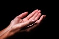 Female hands praying with palms up arms outstretched. Black background Royalty Free Stock Photo
