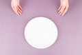 Female hands present an empty plate of food