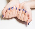 Female hands with professional blue and silver manicure