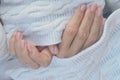 Female hands with professional natural manicure on short nails on the background of a knitted white woolen scarf. Hand care, Royalty Free Stock Photo