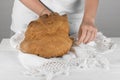 Female hands putting the bread of Matera, Pane di Matera on white background, typical southen italian sourdough bread