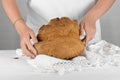 Female hands putting the bread of Matera, Pane di Matera on white background, typical southen italian sourdough bread