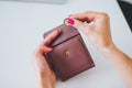 Female hands is putting coins in wallet on pastel faded background Royalty Free Stock Photo