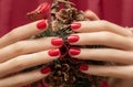 Female hands with red nail design. Glitter red nail polish manicure. Woman hands hold Christmas decoration Royalty Free Stock Photo