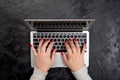 Female hands with red nails typing on laptop on black background. Mockup for business concept or office desktop Royalty Free Stock Photo