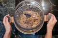 Female hands remove the pan standing on the electric kitchen stove