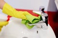 Female hands with rubber protective gloves cleaning tap Royalty Free Stock Photo