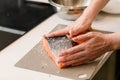 Female hands rubbing with salt fresh salmon fillet