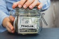 Female hands Saving Money In Glass Jar filled with Dollars banknotes. PENSION transcription in front of jar. Managing Royalty Free Stock Photo