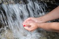 Female hands scoop up water in a fast river Royalty Free Stock Photo