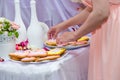 Female hands setting pram shaped gingerbread cookies on white plate. Candy bar with sweets Royalty Free Stock Photo