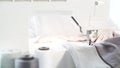 Female hands sew on a white sewing machine close-up