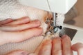 Female hands sewing cotton
