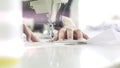 Female hands on white sewing machine, lens flare