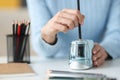 Female hands sharping pencil with electronic sharpener closeup Royalty Free Stock Photo