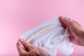 Female hands show a dirty stain on the collar of a white shirt. isolated on pink background Royalty Free Stock Photo