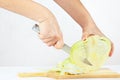 Female hands shred cabbage on a cutting board