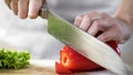 Female hands slicing red pepper by sharp kitchen knife during culinary show