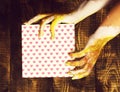 Female hands holding valentine present on brown vintage studio background Royalty Free Stock Photo