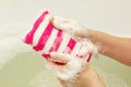 Female hands soaping striped sponge with soap Royalty Free Stock Photo