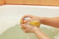 Female hands soaping yellow sponge with soap Royalty Free Stock Photo