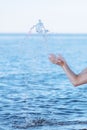 Female hands with splashes of clear blue fresh water in sea. Air bubbles, water drops, sea wave on blue background with Royalty Free Stock Photo