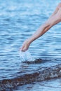 Female hands with splashes of clear blue fresh water in sea. Air bubbles, water drops, sea wave on blue background with Royalty Free Stock Photo