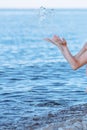 Female hands with splashes of clear blue fresh water in sea. Air bubbles, water drops, sea wave on blue background with Royalty Free Stock Photo