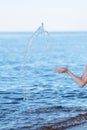 Female hands with splashes of clear blue fresh water in sea. Air bubbles, water drops, sea wave on blue background with Royalty Free Stock Photo