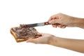 Female hands spread chocolate paste on bread, isolated on white background Royalty Free Stock Photo