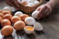 Female hands spread white and brown farm eggs on a wooden table, close-up, low light, selective focus, shallow depth of Royalty Free Stock Photo